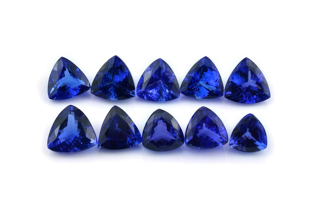 Gemmes de tanzanite bleu violet taillees en triangle aux reflets lumineux symbole de transformation douce et d intuition elevee