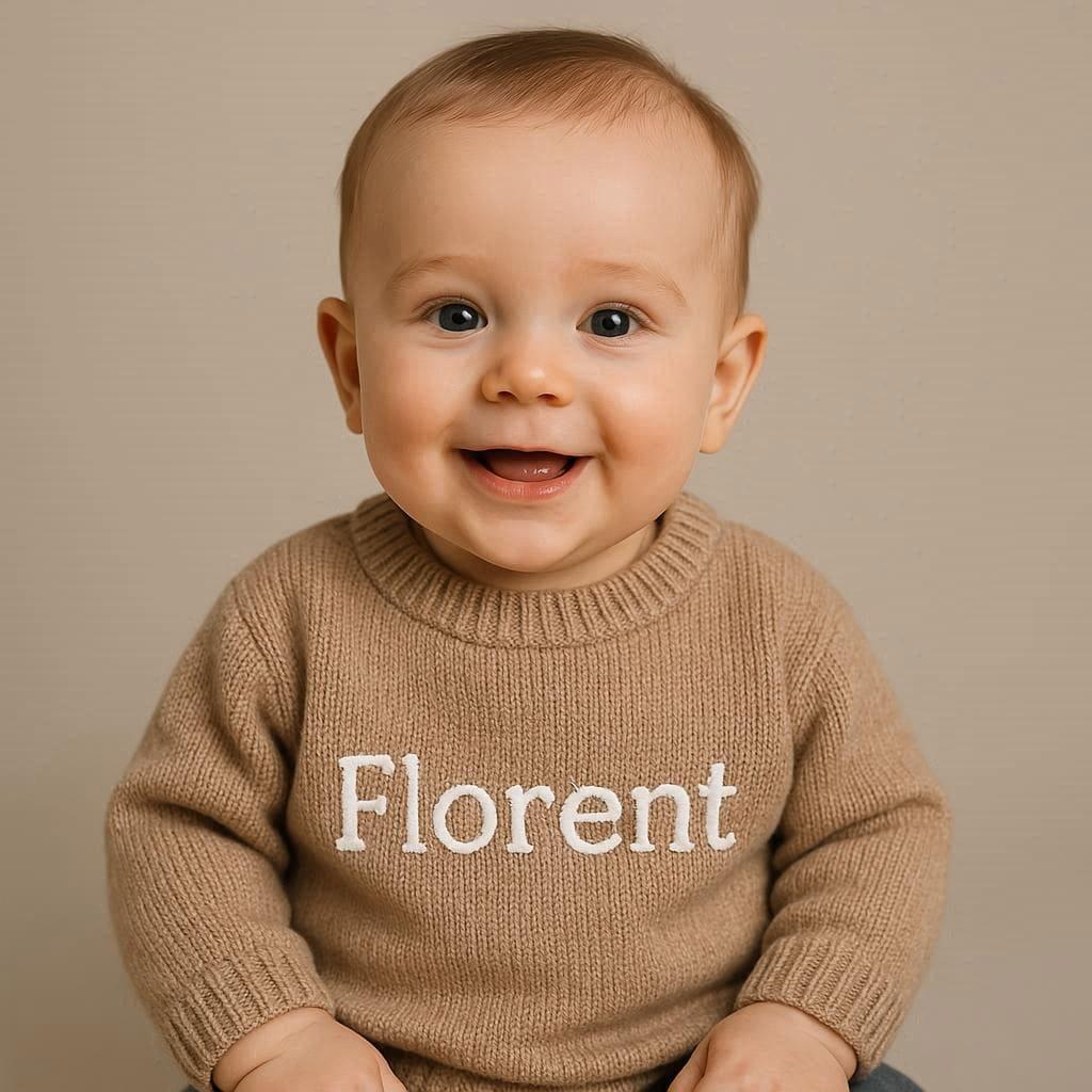 Petit bebe garcon souriant avec son pull personnalise au nom de florent