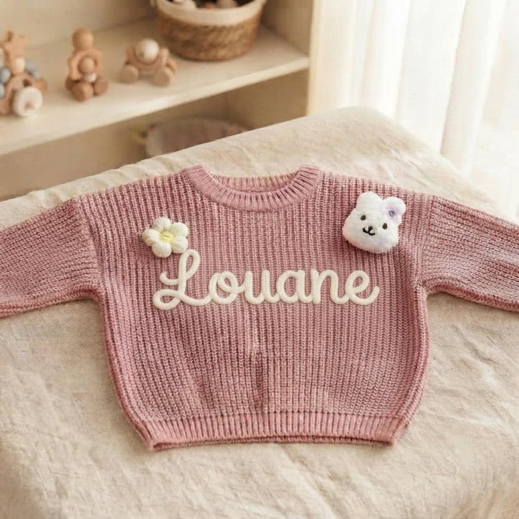 Pull en tricot rose personnalisé avec le prénom Louane, orné d’une fleur et d’un petit lapin brodé, style doux et bohème pour bébé