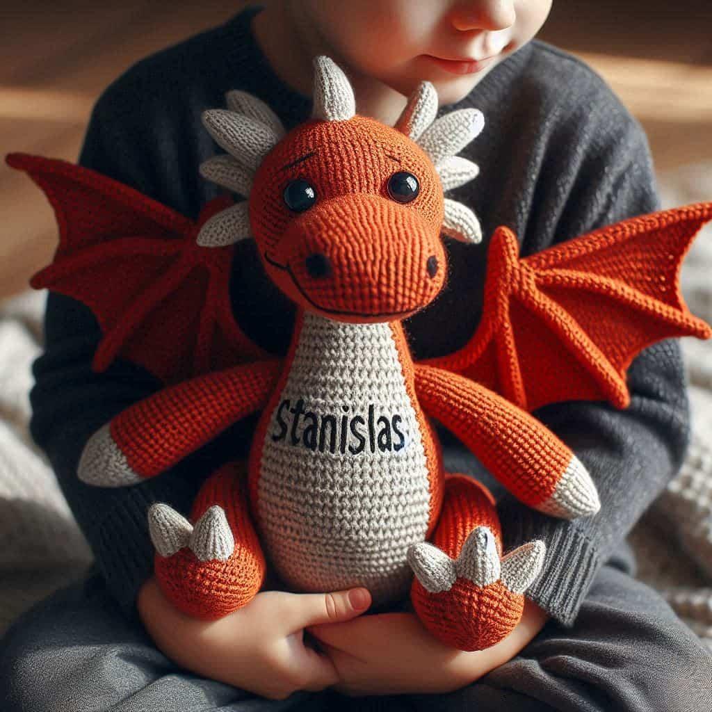 Une peluche dragon en tricotin avec le prenom stanislas