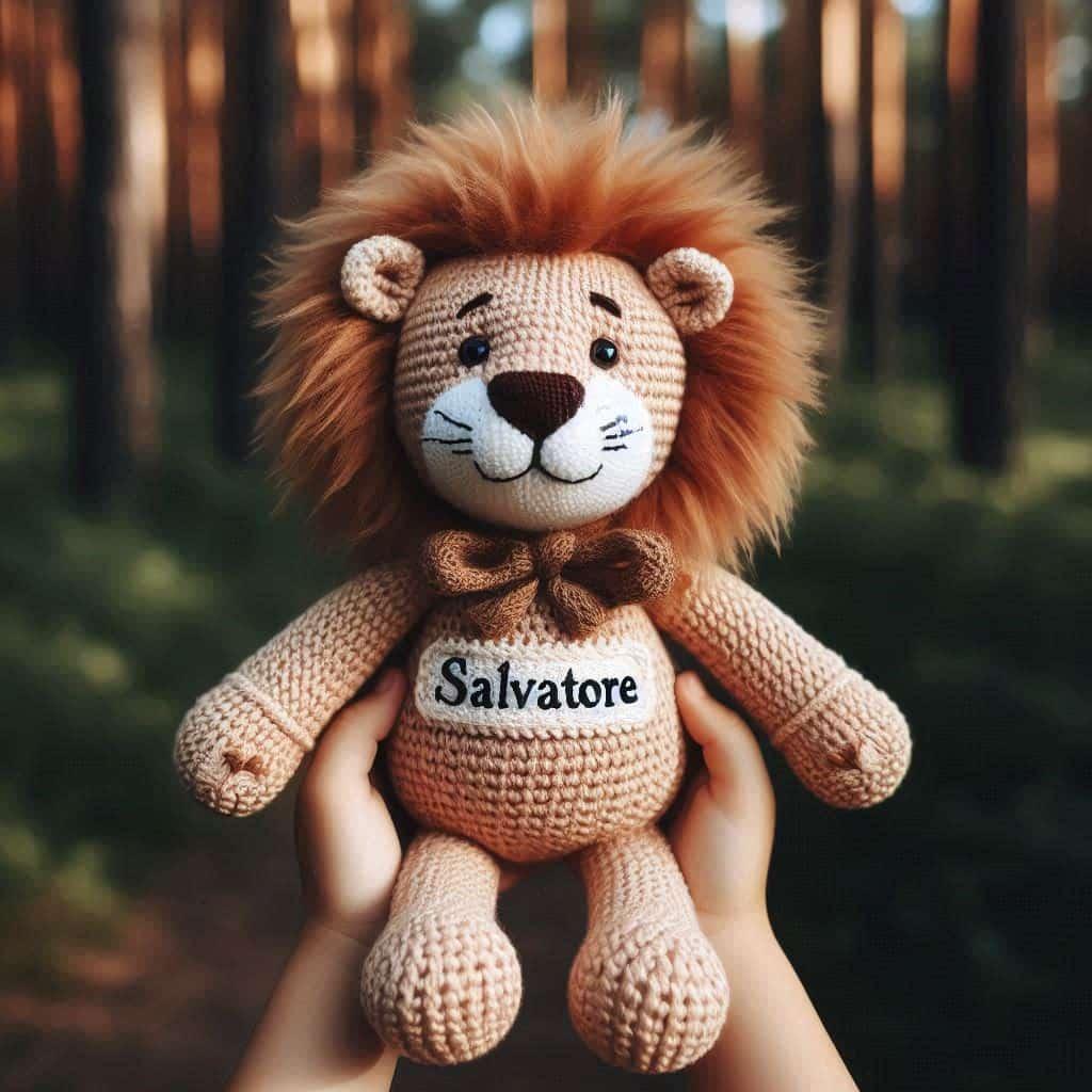 Une peluche lion en tricotin avec le prenom salvatore ecrit en francais tenu dans les mains d un petit garcon